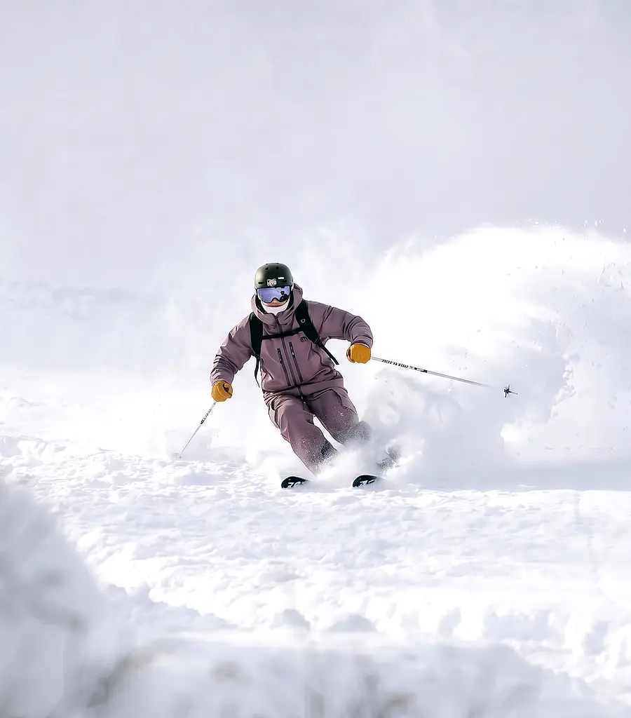 Skier carving through fresh powder off-piste in Chamonix