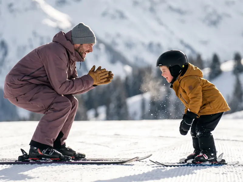 Ski instructor cheering on a young child during a private ski lesson