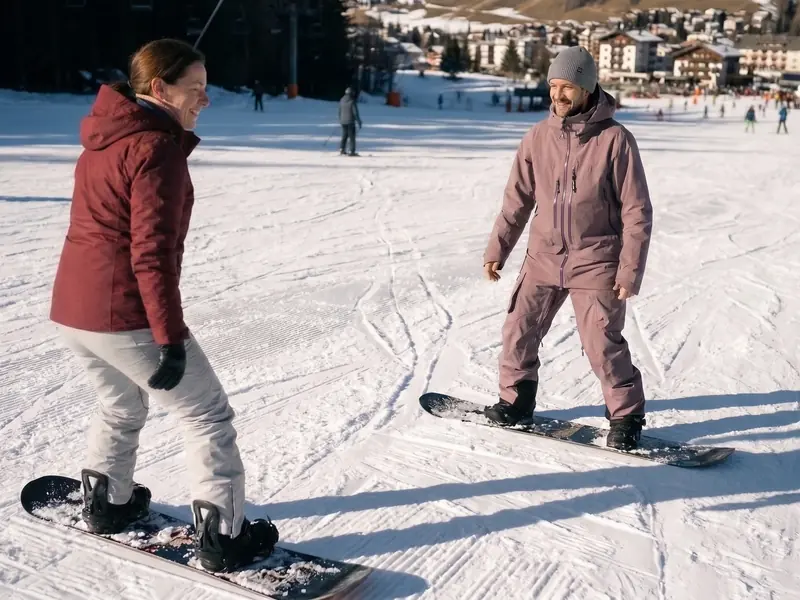 Snowboard instructor teaching a beginner during a snowboard lesson in Chamonix